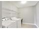 Efficient laundry room featuring a washer, dryer, and shelving for organized storage at 4602 Amesbury Pl, Westfield, IN 46062