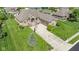 A stunning aerial view of a brick home with a well-manicured lawn, driveway, and charming curb appeal at 4890 Benthaven E Dr, Bargersville, IN 46106