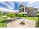 Well-manicured backyard featuring lush greenery, a fire pit, and an attached screened-in porch at 4890 Benthaven E Dr, Bargersville, IN 46106