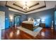 Spacious bedroom with hardwood floors, tray ceiling, chandelier, and ensuite bathroom at 4890 Benthaven E Dr, Bargersville, IN 46106