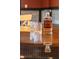 Close-up on a decanter of whiskey and two glasses on a reflective wooden table at 4890 Benthaven E Dr, Bargersville, IN 46106