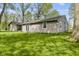 View of back exterior with sliding glass door, window and lush green lawn at 5039 Five Points Rd, Indianapolis, IN 46239