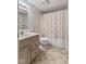 A full bathroom featuring patterned wallpaper, a vanity, toilet, and bathtub with floral shower curtain at 5039 Five Points Rd, Indianapolis, IN 46239