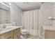 Small, decorated bathroom has patterned wallpaper, a vanity, toilet, and bathtub with shower curtain at 5039 Five Points Rd, Indianapolis, IN 46239