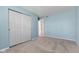 View of the blue-walled bedroom features sliding closet doors and plush neutral carpeting at 5039 Five Points Rd, Indianapolis, IN 46239