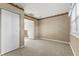 Inviting bedroom with soft carpet, a window, a closet, and an open doorway to another room at 5039 Five Points Rd, Indianapolis, IN 46239