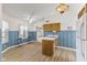 Bright kitchen features laminate floors, wooden cabinets, and vintage wallpaper at 5039 Five Points Rd, Indianapolis, IN 46239