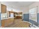 Open kitchen with updated flooring, wooden cabinets, and vintage wallpaper at 5039 Five Points Rd, Indianapolis, IN 46239