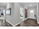 Hallway with a decorative mirror, opening up into another room with lots of natural light at 5062 Foxley Park Ln, Avon, IN 46123