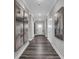 Long hallway with neutral colored walls, modern art, and dark wood flooring at 5062 Foxley Park Ln, Avon, IN 46123