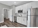Modern kitchen featuring white cabinetry, stainless steel appliances, and elegant gray walls at 5062 Foxley Park Ln, Avon, IN 46123