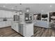 Modern kitchen with a center island, stainless steel appliances, pendant lights, and seamless flow into the living space at 5062 Foxley Park Ln, Avon, IN 46123
