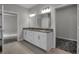 Bathroom with a dual sink vanity, granite countertop, and a view to the bedrooms at 5127 Foxley Park Ln, Avon, IN 46123