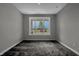 A carpeted bedroom offers a bright and neutral space, complemented by a large window view at 5127 Foxley Park Ln, Avon, IN 46123