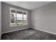 A carpeted bedroom offers a bright and neutral space, complemented by a large window view at 5127 Foxley Park Ln, Avon, IN 46123