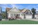 Charming single Gathering home boasts a manicured lawn, two car garage, and inviting covered front porch at 5127 Foxley Park Ln, Avon, IN 46123