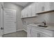 Bright laundry room with white cabinets, countertop, and stainless steel faucet at 5127 Foxley Park Ln, Avon, IN 46123