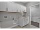 Laundry room features white cabinets, a sink, and a gray tiled floor at 5127 Foxley Park Ln, Avon, IN 46123