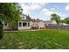 Well-maintained backyard with lush green grass, mature trees, and patio dining set at 5439 Indianola Ave, Indianapolis, IN 46220
