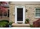 Close up of the front door of a stone house with landscaping and potted plants at 5439 Indianola Ave, Indianapolis, IN 46220
