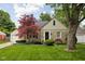 Charming stone home features a well-manicured lawn and a mature maple tree at 5439 Indianola Ave, Indianapolis, IN 46220