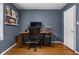 A dedicated home office area with hardwood floors, a modern desk, and a rolling office chair at 5439 Indianola Ave, Indianapolis, IN 46220