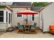 Cozy back patio featuring outdoor dining set and seating with orange umbrella at 5439 Indianola Ave, Indianapolis, IN 46220