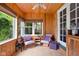 Cozy sunroom with wood paneling, comfortable seating, and natural light, perfect for relaxation at 5439 Indianola Ave, Indianapolis, IN 46220