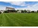 Sprawling backyard with lush green grass, a covered patio, and a view of the home's exterior at 5507 Wakefield Rd, Greenwood, IN 46142