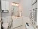 Bright bathroom featuring white fixtures, wainscoting, and a decorative mirror at 5507 Wakefield Rd, Greenwood, IN 46142