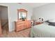 Cozy bedroom featuring light-colored walls, wooden floors, and a large wooden dresser with mirror at 5507 Wakefield Rd, Greenwood, IN 46142