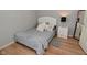 A bedroom features a gray bed, soft rug, and a white nightstand and offers a cozy retreat for relaxation and rest at 5507 Wakefield Rd, Greenwood, IN 46142