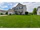 Well-maintained two-story home with a lush green lawn, lovely landscaping, and an attached two-car garage at 5507 Wakefield Rd, Greenwood, IN 46142