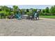 Gravel fire pit area offering Adirondack chairs, woodpile and community pond view at 5507 Wakefield Rd, Greenwood, IN 46142