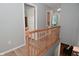 Upstairs hallway with wood railing and floors leads to bedrooms and bathrooms at 5507 Wakefield Rd, Greenwood, IN 46142