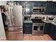 A kitchen boasts stainless steel appliances, granite countertops, and dark blue cabinetry for a modern and stylish cooking space at 5507 Wakefield Rd, Greenwood, IN 46142