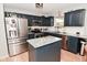 A kitchen with dark blue cabinets, granite countertops, stainless steel appliances, and an island offer modern amenities and style at 5507 Wakefield Rd, Greenwood, IN 46142