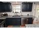 A kitchen featuring granite countertops, stainless steel appliances, and dark blue cabinets offers a contemporary cooking experience at 5507 Wakefield Rd, Greenwood, IN 46142