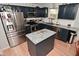 A kitchen with granite countertops, stainless steel appliances, dark blue cabinets, and an island provides a functional and stylish space at 5507 Wakefield Rd, Greenwood, IN 46142