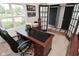 Bright office space with a comfortable desk chair, large window, and adjacent doorways at 5507 Wakefield Rd, Greenwood, IN 46142