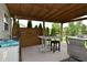 Outdoor kitchen with a built-in sink, refrigerator, bar-height table, and seating on the covered deck at 5507 Wakefield Rd, Greenwood, IN 46142