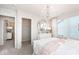 Light-filled bedroom with chandelier, dresser, and view to closet and en suite bathroom at 5784 Summertree Pl, Whitestown, IN 46052