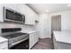 Bright kitchen features stainless appliances, white cabinets and island, and wood grain floors at 5784 Summertree Pl, Whitestown, IN 46052