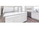 Bright kitchen features stainless appliances, white cabinets and island, and wood grain floors at 5784 Summertree Pl, Whitestown, IN 46052