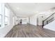 Bright living room features natural light from large windows and a stairway with wood grain floors at 5784 Summertree Pl, Whitestown, IN 46052