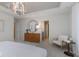 Elegant main bedroom features a tray ceiling, chandelier, seating area, and view into en suite bathroom at 5784 Summertree Pl, Whitestown, IN 46052