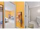 Hallway featuring yellow wall with handbags and open doors to a bedroom and a bathroom at 582 Conner Creek Dr, Fishers, IN 46038