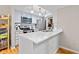 Modern kitchen featuring white cabinets, stainless steel appliances, and a breakfast bar overlooking the living area at 582 Conner Creek Dr, Fishers, IN 46038