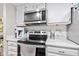 Close-up of kitchen featuring stainless steel microwave, and oven, set against white cabinets and countertops at 582 Conner Creek Dr, Fishers, IN 46038