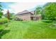Expansive backyard with a brick home, mature landscaping, and a serene, private outdoor space at 5851 Beisinger Pl, Indianapolis, IN 46237